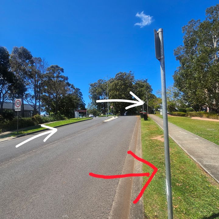 Road leading up towards the hospital and the roundabout, with white arrows showing the right turn at the roundabout and a red arrow pointing to where our rooms are